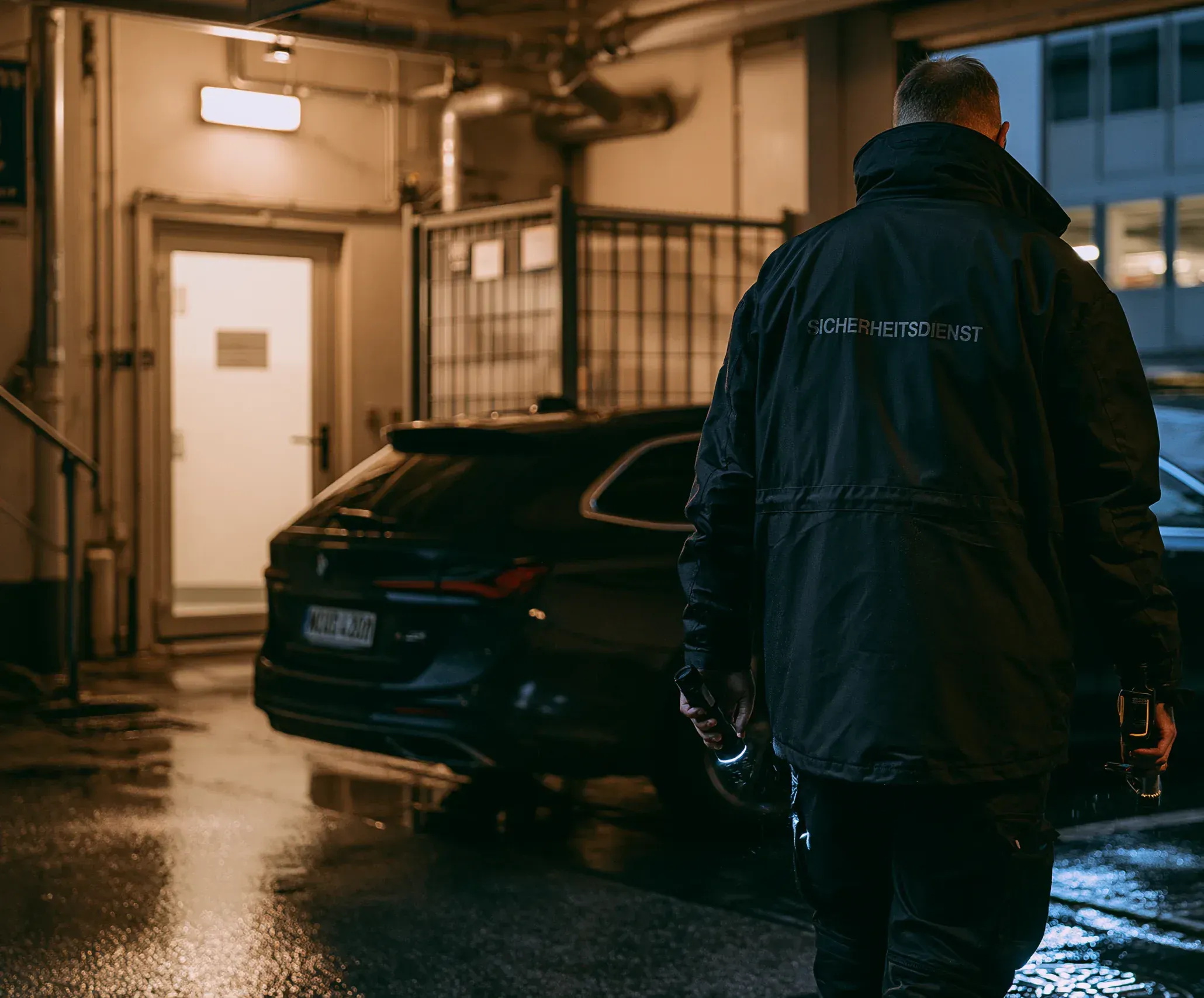 Mitarbeiter des Sicherheitsdienstes auf einem Kontrollgang in einer Tiefgarage bei Nacht